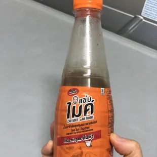 a hand holding a bottle of juice