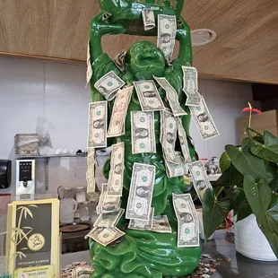 a green vase with money on it