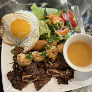 Rice, beef short ribs, grilled shrimps, crispy egg rolls, runny egg.