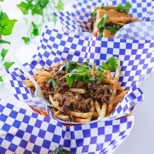 Viet fries - large portion of fries topped with grilled pork belly, onions, cilantro, and our house sauce