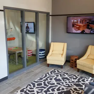 Comfortable waiting room with enclosed kids room.