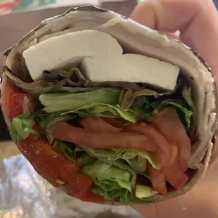 a hand holding a sandwich