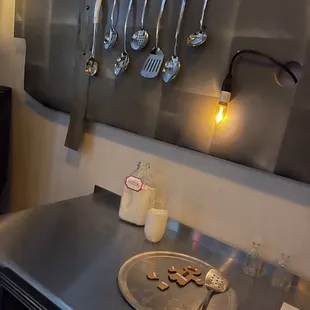 a kitchen counter with utensils hanging on the wall