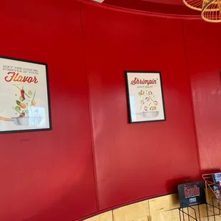 a red wall with posters on it