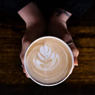 a person holding a cup of coffee