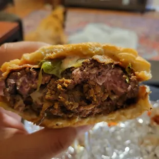 a hand holding a half eaten burger