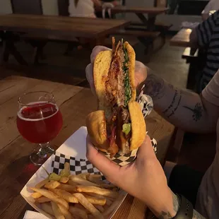 a person holding a sandwich and fries