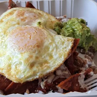 Chilaquiles plate with a side of guac and eggs