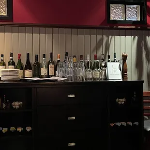 a bar with wine bottles and glasses