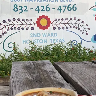 a bowl of soup on a picnic table