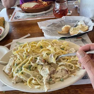 a plate of pasta with chicken and peas