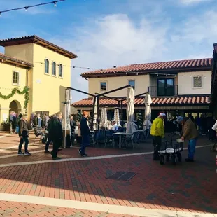 a crowd of people walking around a plaza