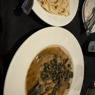 two plates of pasta and meat