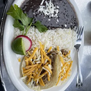 Two tacos, rice and beans. I swapped cheese in for the more authentic onion/cilantro toping