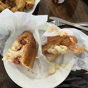 Meatball sub with cheese stuck to the paper.