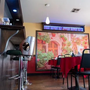 a dining room with red tablecloths and chairs