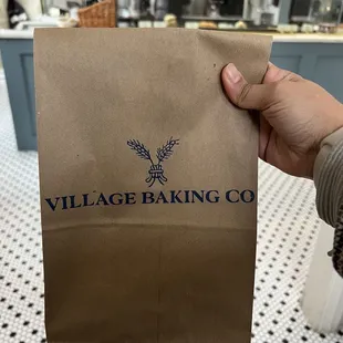 a person holding a bag of bread