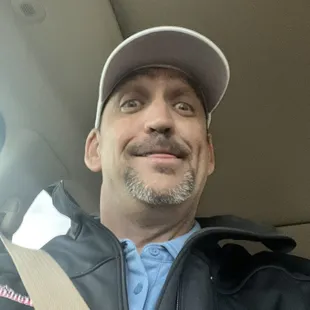 a man in a leather jacket and hat