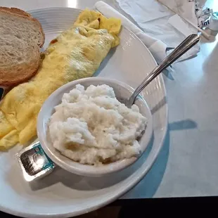 Omelet with Sausage, Bacon, Ham, and Cheese. Side order of clumpy and cold grits, and cold toast.