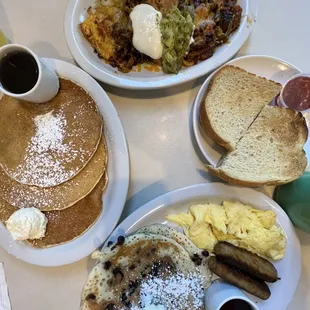 a breakfast of pancakes, eggs, toast, and coffee