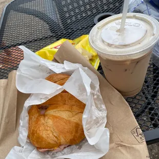 a croissant sandwich and a drink