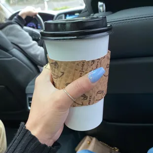 a hand holding a cup of coffee