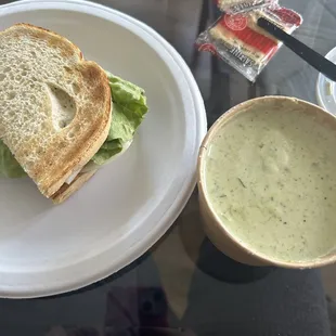 Half all-natural roasted turkey breast sandwich and a cup of spinach soup.