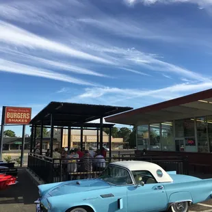 a classic car parked in front of a diner