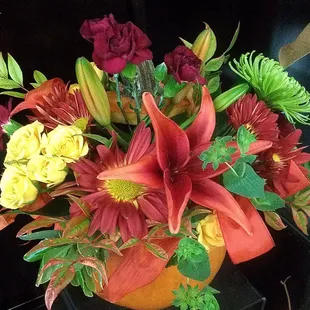Beautiful fall flowers in a fresh carved pumpkin create the perfect table arrangement.