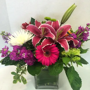Square cube with stargazer lilies, stock, spider mums and more.