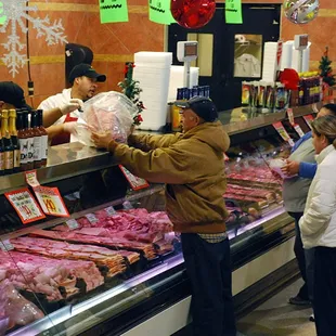 a man and a woman shopping for meat