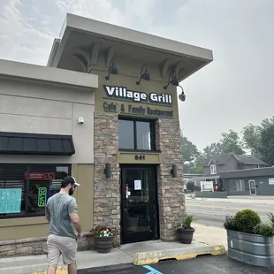 a man standing in front of a restaurant