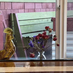 a vase of flowers in front of a window