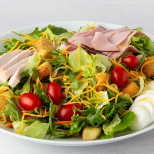 Celebrity Chef Salad, topped with turkey breast, ham, Cheddar cheese, tomato, hard‑boiled egg and seasoned croutons on healthy mixed greens