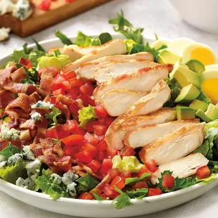 Classy Cobb Salad, with juicy grilled chicken breast, bacon, avocado, hard-boiled egg, tomato, crumbled Bleu cheese on healthy mixed greens