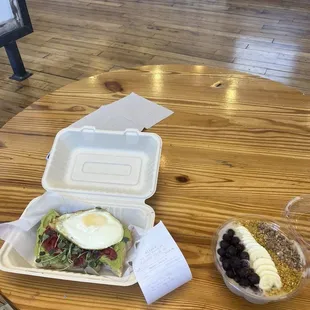 a sandwich and a salad in a styrofoam container