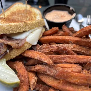 REUBEN (corned beef, Swiss cheese, sauerkraut, and Russian dressing on grilled rye) with sweet potato fries and a dill pickle spear