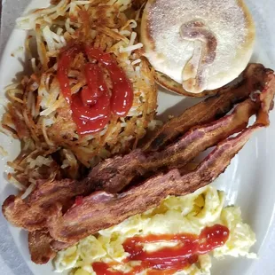 Two egg breakfast, crispy bacon, English muffin, scrambled eggs.