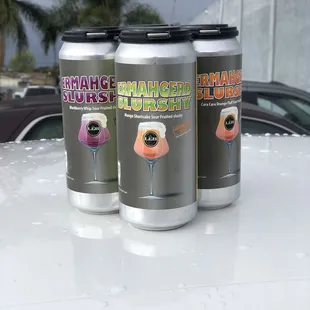 three cans on the hood of a car