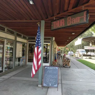 storefront with american flag on sidewalk