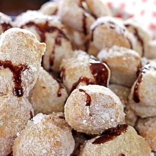 a plate of powdered sugared donuts