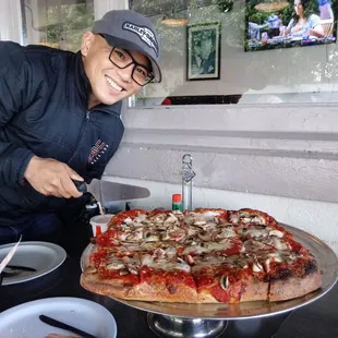 My husband with our large Sicilian pizza.