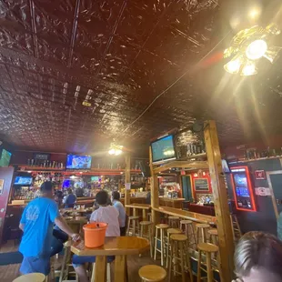 people sitting at tables and watching televisions