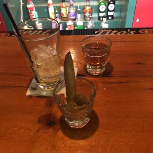 a glass of whiskey and a pickle