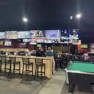 One of the pool tables and some of the 47 TVs; stage for band in front