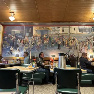 a mural of people sitting at tables