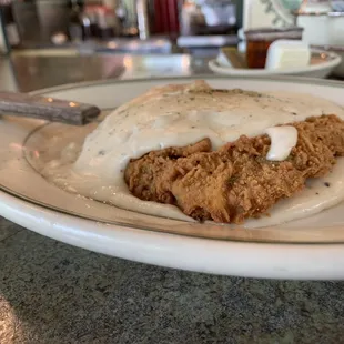 a plate of fried chicken with gravy and gravy sauce