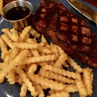 a steak and fries on a blue plate