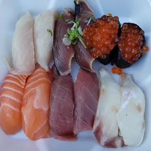 a variety of sushi in a styrofoam container