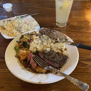 Steak medium well with a bourbon and a butter sauce a baked potato and a salad